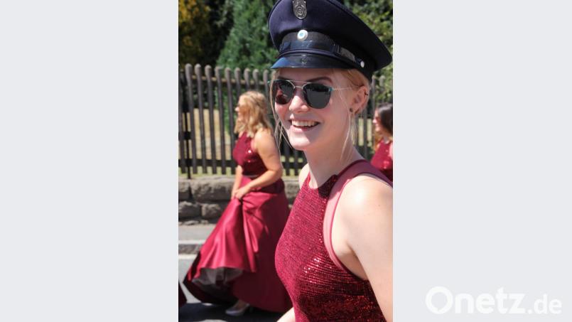 Schutz vor der Sonne: Eine Festdame mit Feuerwehrmütze. Bild: kro