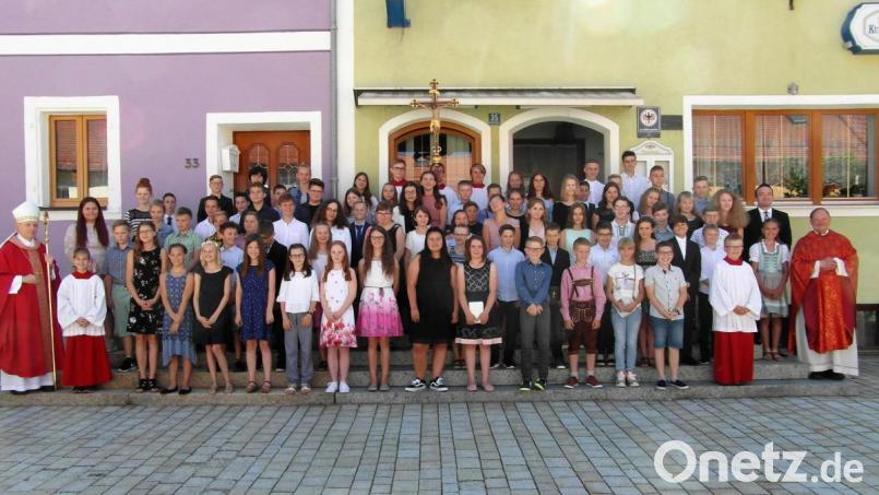 Auf den Stufen des Gasthauses Merkl stellen sich Weihbischof Reinhard Pappenberger (links) und Pfarrer Heribert Stretz (rechts) mit den Firmlingen aus Waldeck und Kastl zum Gruppenbild auf. Der Oberhirte steht den Jugendlichen und ihren Paten anschließend auch noch für Einzelfotos zur Verfügung. Bild: hl