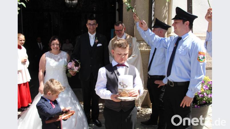 Bianca und Christoph Rustler mit Stadtpfarrer Thomas Vogl beim Verlassen der Basilika. Die Feuerwehr Querenbach stand Spalier. Bild: kro