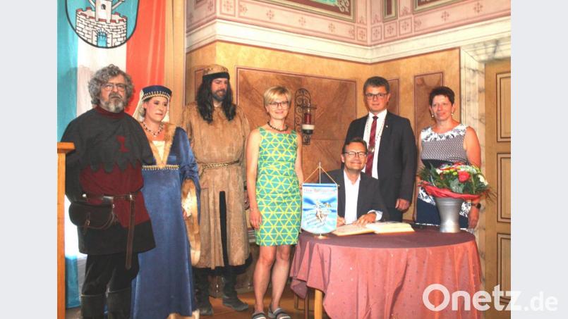 Schirmherr Reimund Gotzel trägt sich ins Goldene Buch ein. Daneben stehen (von rechts) Zweite Bürgermeisterin Margit Reichl, Bürgermeister Martin Birner, Beate Rubenbauer, das Pfalzgrafenpaar Michael Hellmuth und Silke Biegerl sowie der Vorsitzende des Festspielvereins, Helmut Mardanow. Bild: lg