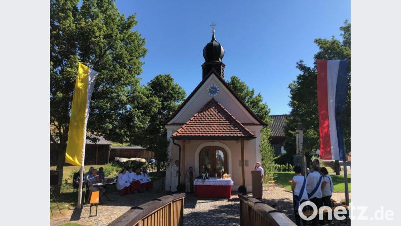 Vorsitzender Adolf Legath (am Rednerpult) freut sich, dass trotz der sommerlichen Hitze so viele Gläubige zum Kapellenfest nach Reuth gekommen sind. Bild: jzk
