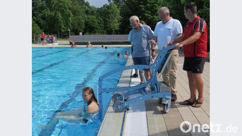 Michaela Krämer stellte sich für den Premiereneinsatz des Pool-Lifters im Erlebnisbad zur Verfügung. Bademeister Michael Maget, Oberbürgermeister Andreas Feller und Bäderleiter Rüdiger Frey (von rechts) hoben sie ins Wasser. Bild: Hirsch