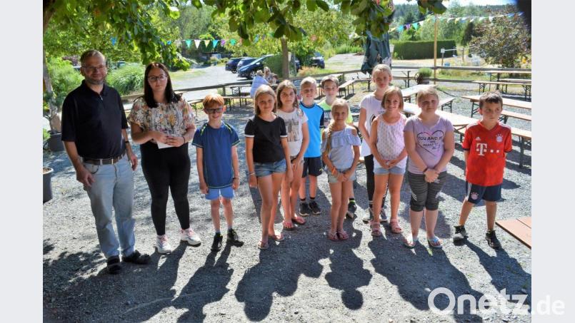 Pfarrer Thomas Stohldreier übergibt Pia Baudler (von links) gemeinsam mit den Kommunionkindern den gesammelten Geldbetrag. Bild: fz