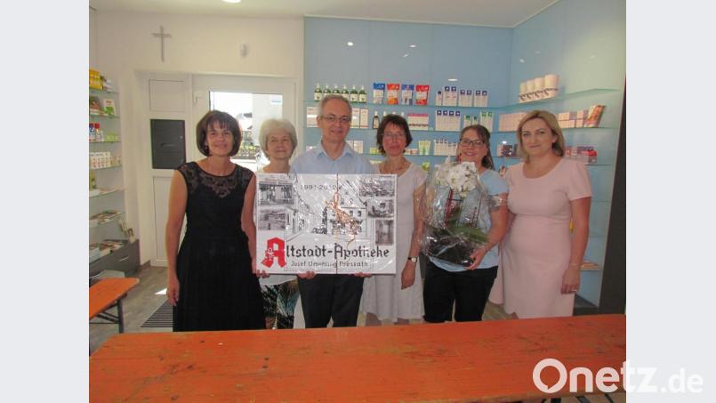 Die Mitarbeiterinnen überraschen die Apotheker Josef Gmehling und seine Frau Monika mit einer Collage, die Bilder der alten Apotheke in der Schulstraße zeigt. Bild: is