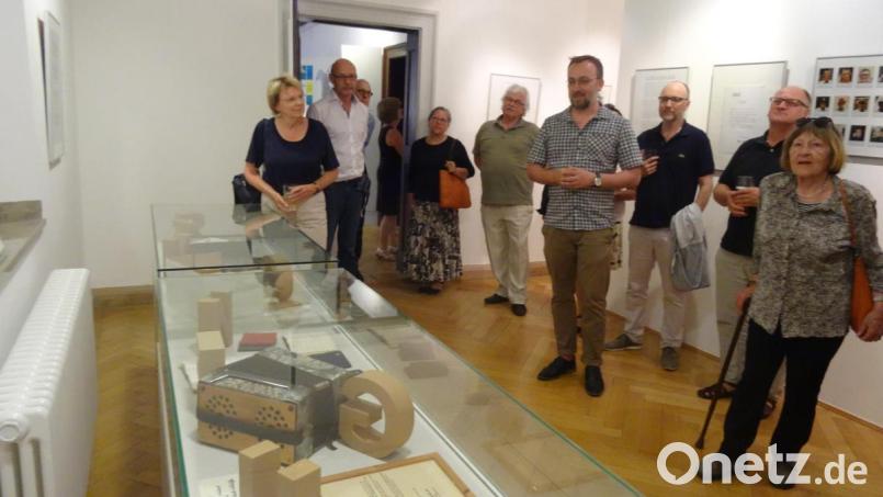 Archivleiter Michael Hehl (Vierter von rechts) zeigt den Vernissage-Besuchern Eugen Okers Notizbücher und Briefe. Bild: hka