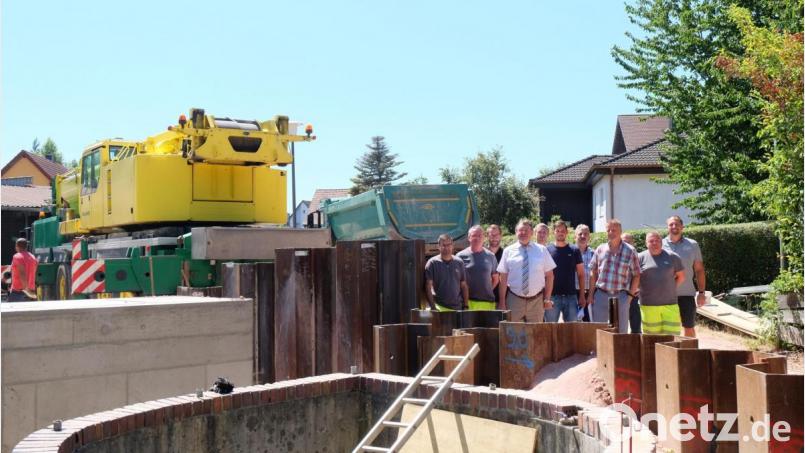 Bevor die Spundwand mit dem großen Spezialkran wieder herausgezogen wurde, trafen sich die Vertreter der Baufirmen zusammen mit Bürgermeister Hans-Martin Schertl (Mitte) und Bauamtsleiter Stefan Ertl (rechts) mit den Mitarbeitern des Klärwerks zu einer Baubesprechung von dem neuen Pumpwerk. Bild: Stefanie Gradl