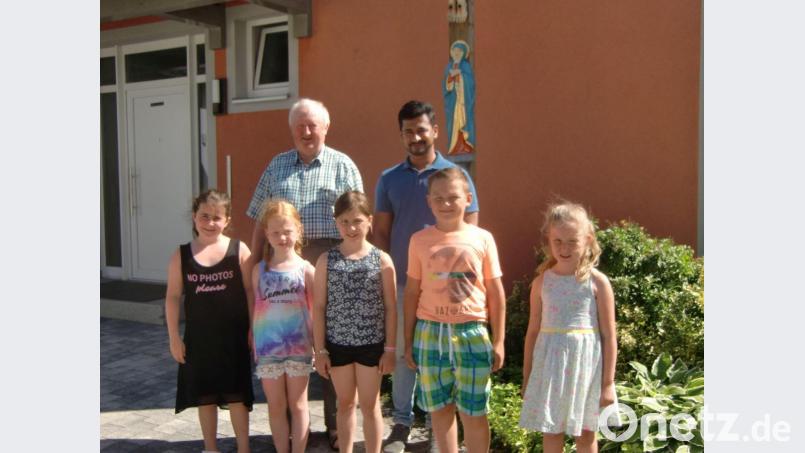 Pfarrer Erwin Bauer und Pfarrvikar Bivin begrüßen die neuen Minis. Bild: gz
