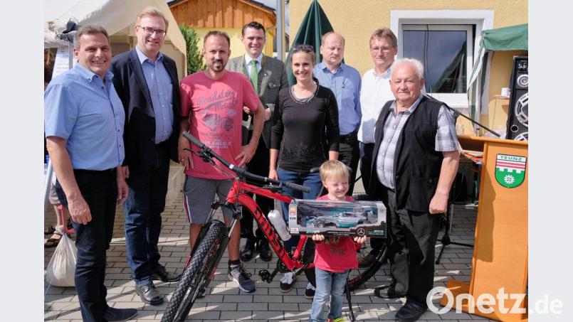Ortsvorsitzender Adolf Hammer (Zweiter von rechts) übergibt die Preise an die glücklichen Sieger Matthias Bauer (1. Platz, pinkes T-Shirt) und Juliane Ried mit Sohn. Den Siegern des Entenrennens gratulierten die Ehrengäste (von links) Bürgermeister Norbert Eckl, MdL Alexander Flierl, Landrat Thomas Ebeling, Robert Hechtl (CSU Wildstein) und Altbürgermeister Josef Klier. Bild: tkr