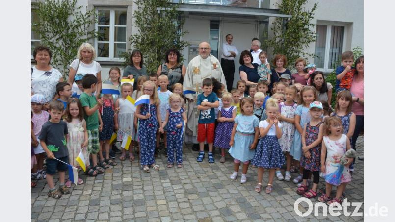 Kindergartenkinder nahmen Stadtpfarrer Anton Witt beim Pfarrhof in die Mitte. Bild: jr