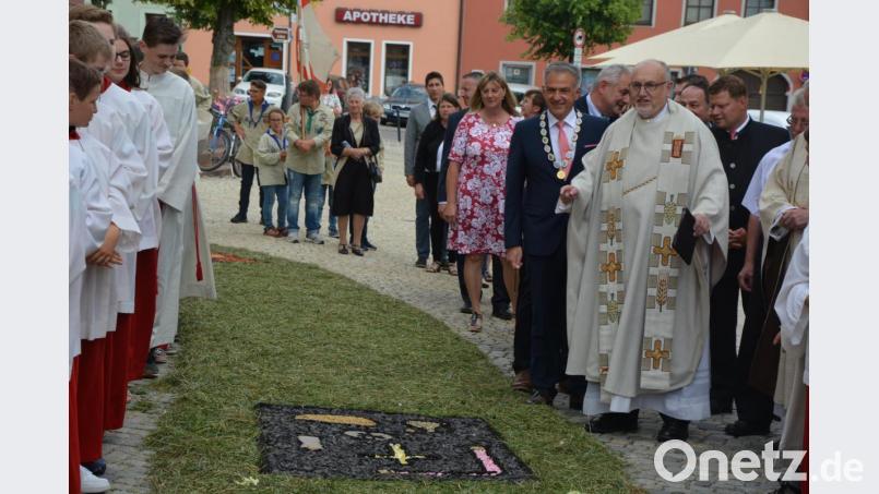 Stadtpfarrer Anton Witt und Bürgermeister Roland Grillmeier bestaunen den Blumenteppich. Bild: jr