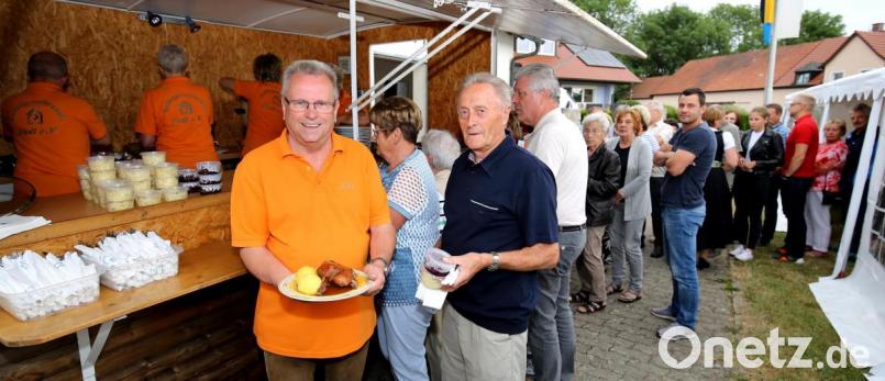 Schlange stehen die Besucher beim Siedlerfest am Grillwagen, um eines der begehrten Gerichte zu bekommen. Den ersten Entenbraten präsentiert Vorsitzender Josef Barth. Bild: mef