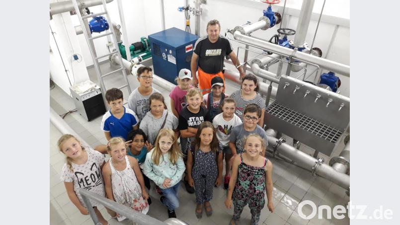 Wasserwart Armin Bauer (im Hintergrund) erklärt der Klasse Zusammenhänge und Wege rund um die Versorgung der Bevölkerung mit Trinkwasser. Bild: fjo