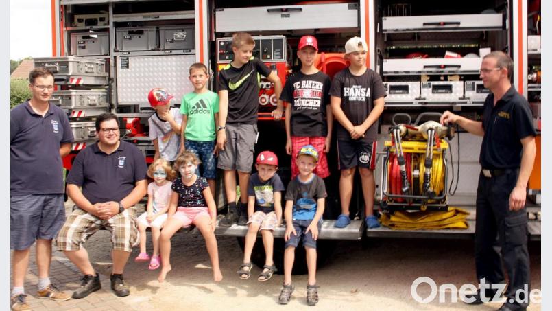 Die Kinder und Jugendlichen zeigen viel Interesse am Rüstwagen der Feuerweh, bevor sie zu einer Rundfahrt mit Blaulicht durchs Dorf aufbrechen. Bild: zer