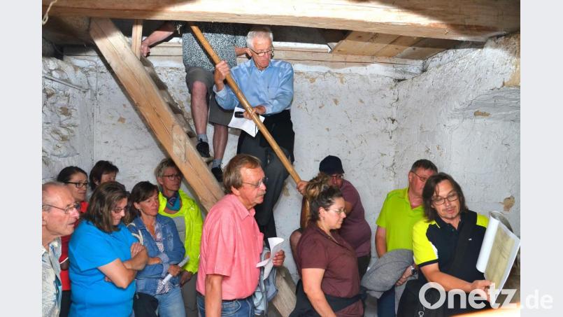 Mit großen Farbkopien von neu entdeckten Plänen und Ansichten überrascht Ortsheimatpfleger Andreas Ringholz (rechts) die Teilnehmer der Exkursion auf engstem Raum im Kirchturm. Bild: fjo