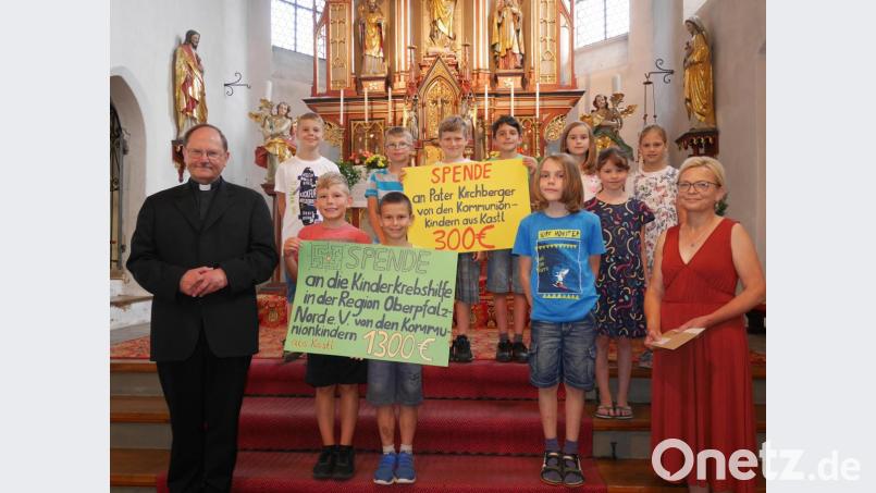 In einer von Pfarrer Heribert Stretz (links) zelebrierten Kindermesse überreichen die Erstkommunikanten 1300 Euro an Waltraud Wagner (rechts) von der Kinderkrebshilfe in der Region Oberpfalz-Nord. Bild: exb