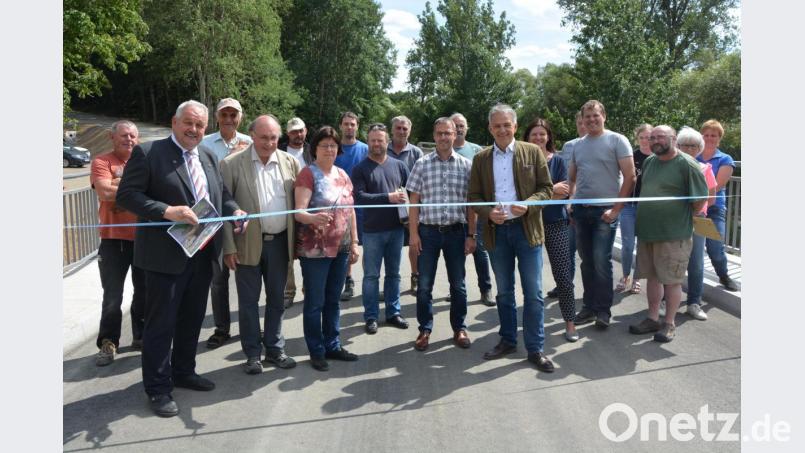 Mit dem symbolischen Durchschneiden eines weiß-blauen Bandes wurde die Straße wieder für den Verkehr freigegeben. Über die Fertigstellung des Projekts freuten sich unter anderem Bürgermeister Johann Burger (vorne links) und Mitterteichs Bürgermeister und VG-Vorsitzender Roland Grillmeier (vorne rechts). Bild: jr