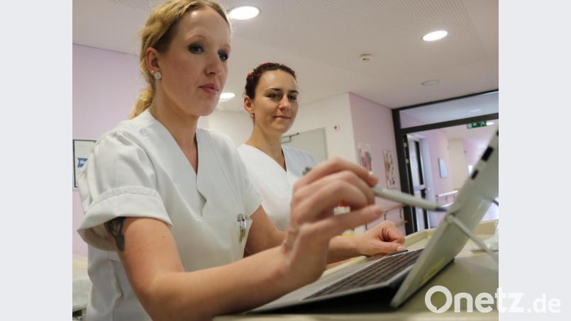 Pflegekraft Simone Markus und Stationsleitung Ramona Pietsch (von links) geben Patientendaten in eines der neuen Tablets ein. Bild: exb