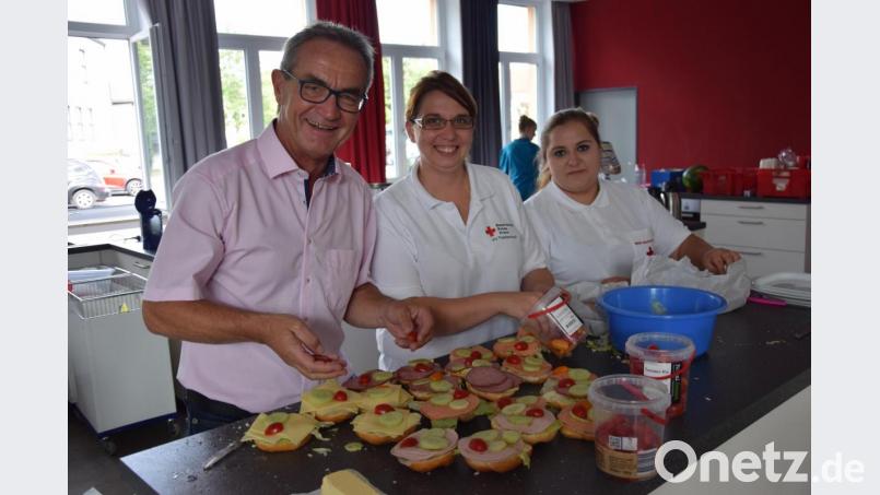 Bürgermeister Werner Nickl löst seine Wettschulden ein und unterstützt die Leiterin der Kemnather Rotkreuz-Bereitschaft, Kristina Konz sowie die Leiterin des Sozialdienstes, Patricia Oettl (von links), beim Belegen der Wurst- und Käsesemmeln. Bild: mde