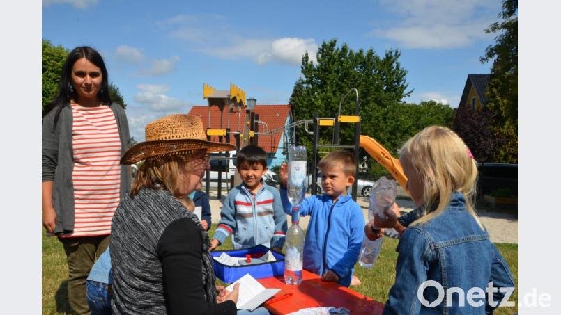 Mit Anke Dirscherl (sitzend) erarbeiten die Kinder, wie leer eine Flasche ist und Wasser die Luft verdrängt. Bild: dob
