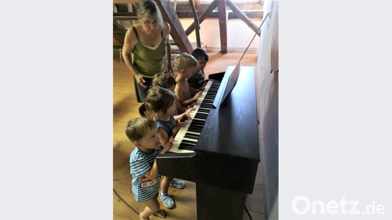Die Musikgarten-Kinder von Lehrkraft Andrea Kick (links) probieren das Klavier aus. Bild: kia