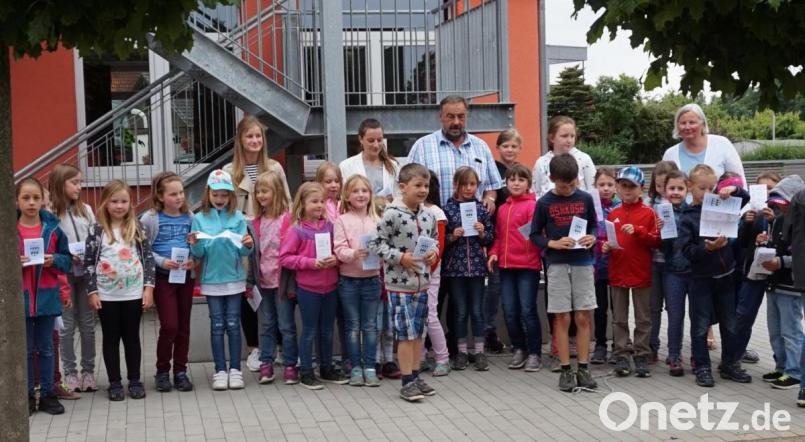 Den druckfrischen Ferienprogrammflyer stellen Anna-Lena Bojer von der Marktverwaltung, Bürgermeister Josef Beimler und Gemeinde -Praktikantin Dahlia Hoffleuchter-Novarro der Grundschulrektorin Carina Hartwig (von links) und den Kindern der Wolfgang-Caspar-Printz-Grundschule vor. Bild: fvo