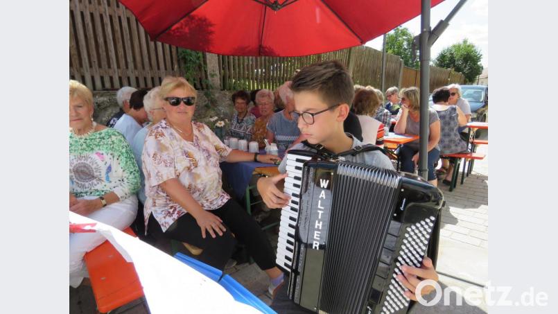 Weil's gar so heiß war, mischte sich Akkordeonspieler Simeon Franz unter die Gäste, die unter Sonnenschirmen Schutz vor der Sonne suchten. Bild: ubb