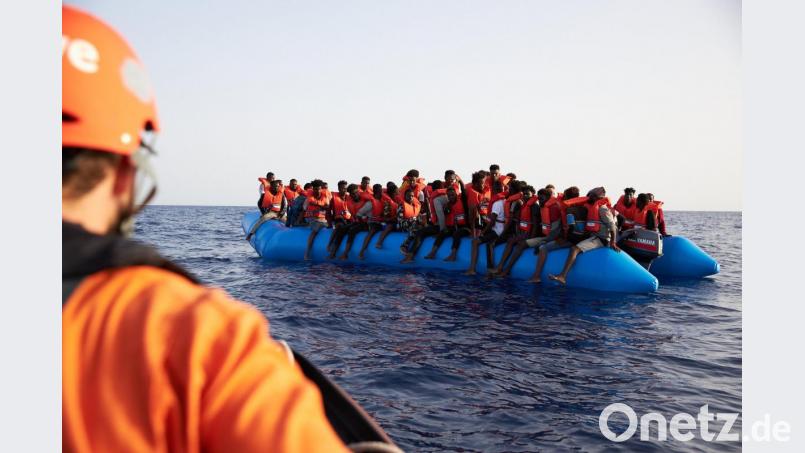 Die von der Seenotrettungsorganisation Sea-Eye herausgegebene Aufnahme zeigt einen Seenotretter, der zu einem Flüchtlingsboot schaut. Bild: Fabian Heinz/Sea-Eye/dpa