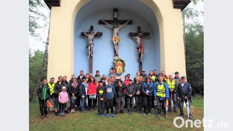 Sie trotzen den Wettervorhersagen und marschieren betend von Pegnitz über Pottenstein in den fränkischen Wallfahrtsort Gößweinstein: An der Kreuzkapelle auf der Anhöhe über Pottenstein legen die Schlammersdorfer Pilger einen kurzen Stopp ein, bevor sie das letzte Wegstück in Angriff nehmen. Bild: wmi