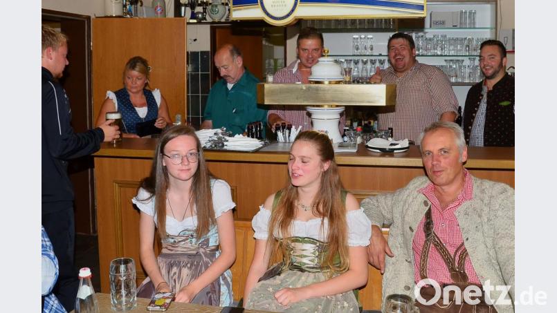 Ein Herrenquartett um Dominik Zintl (rechts) kümmert sich um den Ausschank am Tresen. Viele Besucher genießen in Dirndl und Lederhosen das bayerische Ambiente. Bild: fjo