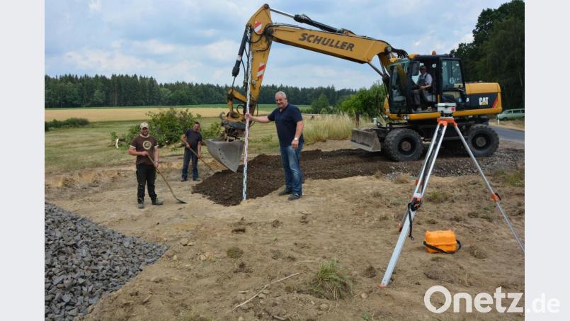 Bürgermeister Johann Burger (Mitte), Gemeinderat Alois Männer (im Bagger) und weitere Helfer packten am Freitag kräftig mit an, um am Ortseingang von Münchsgrün einen Buswendeplatz zu erstellen. Bild: jr