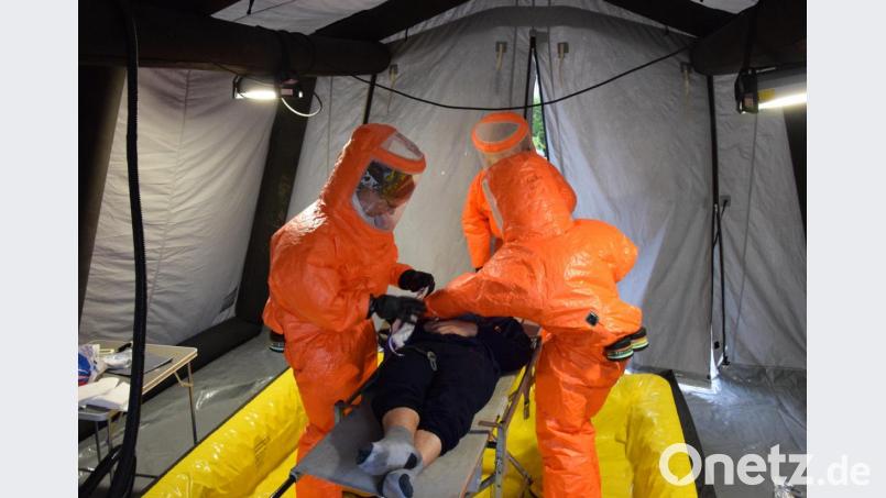 Einsatzkräfte des BRK-Fachdienstes CBRN(E) führen die Ganzkörper-Nassreinigung eines &quot;Verunfallten&quot; durch. Bild: mde
