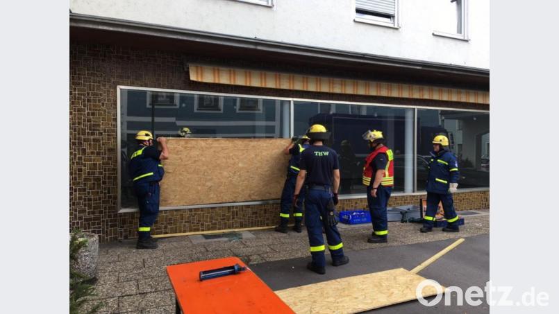 THW-Leute sichern die Bruchstelle im Schaufenster ab, damit sich niemand verletzen kann. Bild: ihl