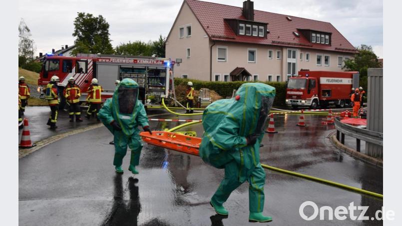 Der Sicherheitstrupp, ebenfalls mit Chemikalienschutzanzügen (CSA) ausgerüstet, begibt sich in den Gefahrenbereich um den verunfallten Kameraden zu retten. Dazu wird auch eine Schleifkorbtrage als Transportmittel mitgenommen. Bild: mde