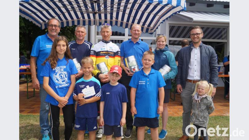 Bürgermeister Ernst Lenk (rechts) und Radsportchef Markus Dobmeier (links) zeichnen bei der Siegerehrung die Vertreter der teilnehmerstärksten Vereine und Ortsgruppen mit Bierpreisen aus. Die SpVgg-Kinder (vorne) erhalten einen Gutschein für Süßigkeiten. Bild: du