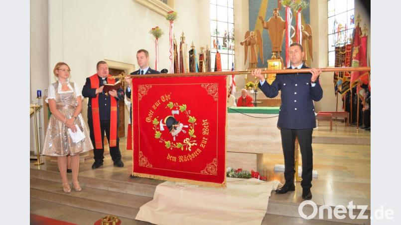 Robert Mark und Christian Münchmeier halten die Fahne, die Pfarrer Hubert Bartel segnet. Worte dazu spricht Fahnenbraut Nicole Münchmeier Bild: fz