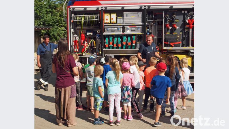 Die Feuerwehrler Ronald Weiß und Josef Piller (links) staunten über das Interesse der Kinder, als sie ihnen das HLF 20 erläuterten. Bild: sön