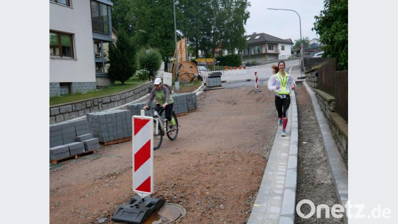 Die Läufer nehmen mit ihrer Begleitung durch eine Öffnung an der Straßenbaustelle Tillyplatz den kürzeren Weg durch Eslarn. Bild: gz