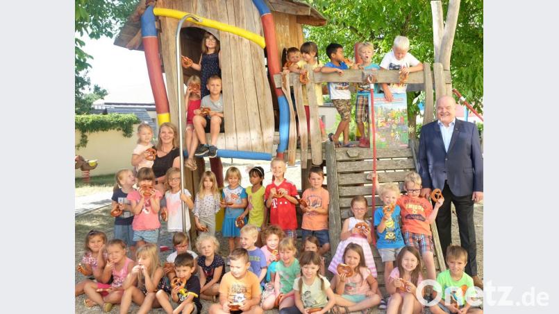 Der Kindergarten St. Christophorus Stulln beteiligte sich am Kita-Wettbewerb des Handwerks „Kleine Hände – große Zukunft“. Als Dankeschön fürs Mitmachen verteilte der Vizepräsident der Handwerkskammer Niederbayern/Oberpfalz, Albert Vetterl (rechts), im Beisein von Sonja Reitinger (links) Brezen an die Mädchen und Buben. Bild: ohr