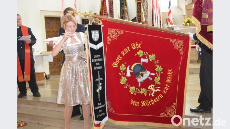 Fahnenbraut Nicole Münchmeier heftet ihr Fahnenband an die Fahne. Bild: fz