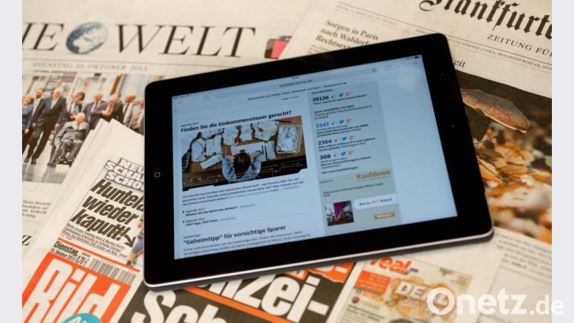Ein Tablet mit einer Online-Zeitung auf dem Bildschirm liegt auf einem Tisch mit Zeitungen. In Zeiten der Digitalisierung ändert sich für Journalisten so vieles in rasender Geschwindigkeit. Archivbild: Sven Hoppe/dpa