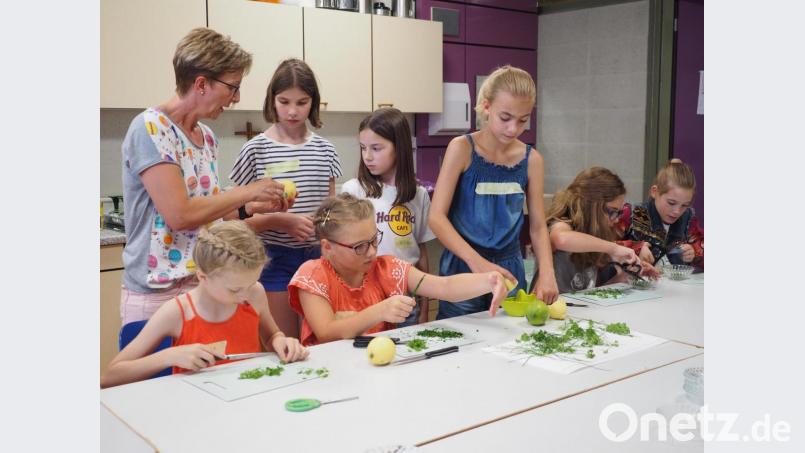 Unter Anleitung von Ulrike Rauch (links) bereiten die Fünftklässlerinnen verschiedene Kräuter-Gerichte in der Schulküche zu, Bild: Elly-Heuss-Gymnasium