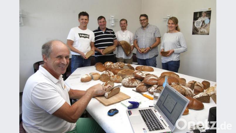 Prüfer Manfred Stiefel (links) bewertete 65 Brot- und Semmelsorten der fünf teilnehmenden Bäckermeister (im Hintergrund). Bild: Hirsch