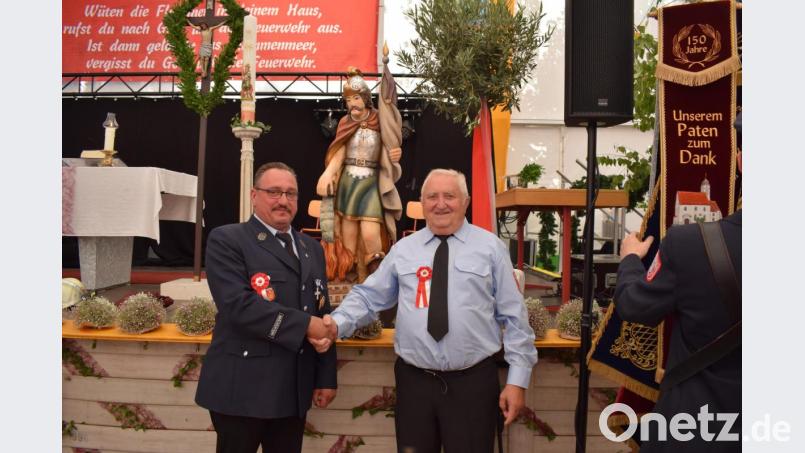 Mit einem ganz besonderen Erinnerungsgeschenk überraschte Franz Paulus (rechts) seine Feuerwehrkameraden. Die Statue des heiligen Florian findet einen Ehrenplatz im Feuerwehrhaus, versicherte Vorsitzender Markus Muntanjohl. Bild: bnr