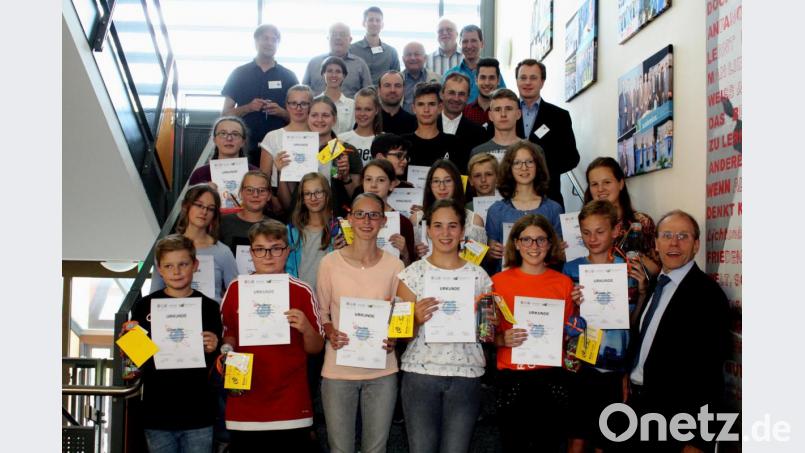 Schulleiter Ludwig Pfeiffer (rechts) gratuliert den sieben erfolgreichen Forscherteams. Mit auf dem Bild die Juroren und Organisator Johannes Klug (hinten, rechts). Bild: lg