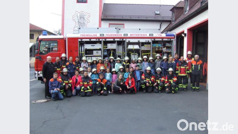 Die Besuchergruppe des städtischen Kindergartens und einige Aktive vor einem Einsatzfahrzeug der Feuerwehr Mitterteich. Bild: exb