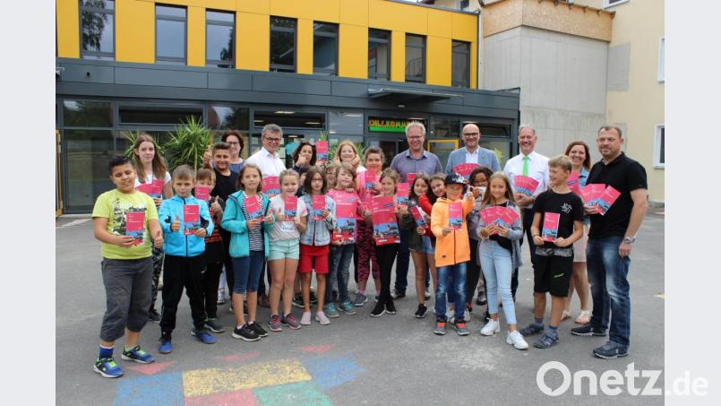 Die Schüler der Neunburger Grundschule in der Ledererstraße waren die ersten, die das druckfrische Ferienprogramm aus den Händen von Bürgermeistern, Verwaltungsmitarbeitern und Vertretern der ArGe Jugend überreicht bekamen. Bild: pko