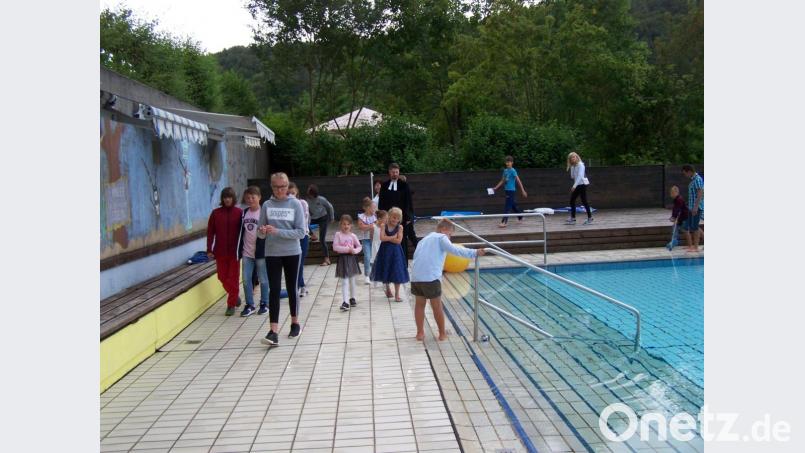 Ein Täufling (Vordergrund) hält bereits ein Bein ins Wasser. Sein Bruder hat mit eingegipstem Fuß ein kleines Handicap, folgt aber tapfer dem Zug zum Wasser Bild: rrd