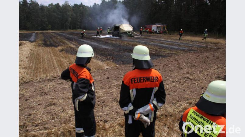 Feuerwehrleute löschen eine Heuballenpresse und das Stoppelfeld bei Neudorf. Bild: Zaruba
