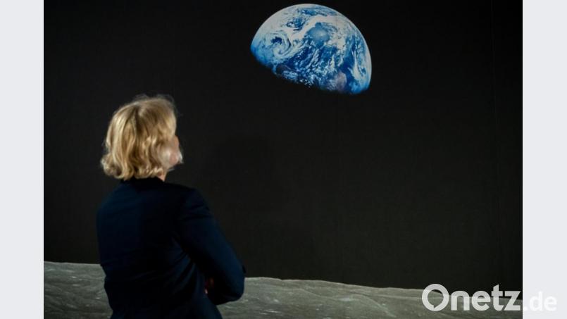 Eine Frau betrachet das Bild &quot;Earthrise&quot;. Bild: Daniel Karmann