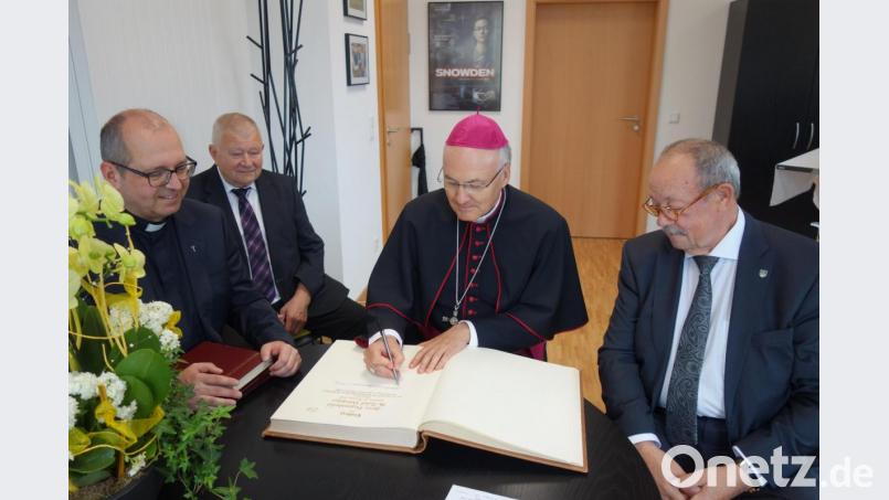 Bischof Rudolf Voderholzer (Zweiter von rechts) trägt sich in das Goldene Buch ein. Mit im Bild (von links): Pfarrer Andreas Weiß, Kirchenpfleger Konrad Gleixner und Bürgermeister Frankl. Bild: exb